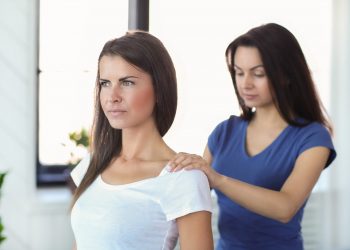 Woman is getting physical therapy from a professional doctor